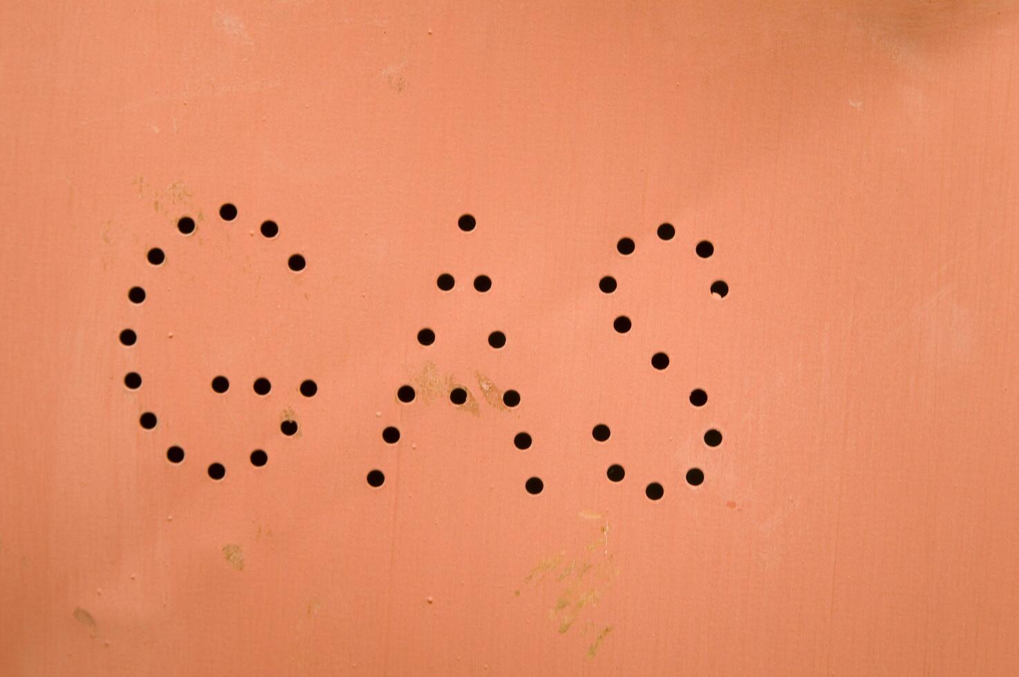 a gas station sign with holes in it photo