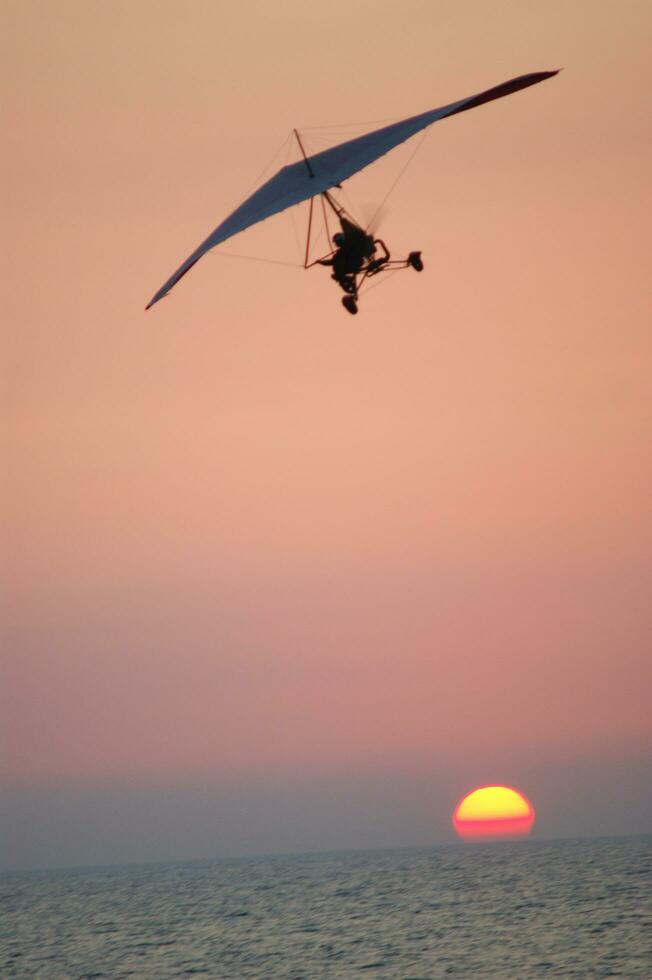 a hang glider is flying in the air photo