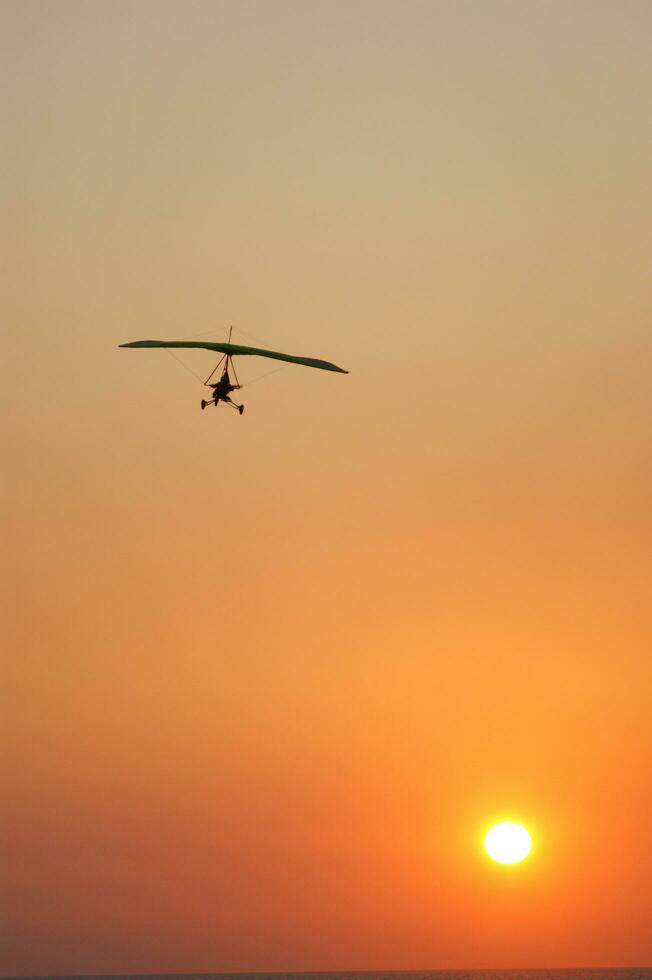 a hang glider is flying in the air photo