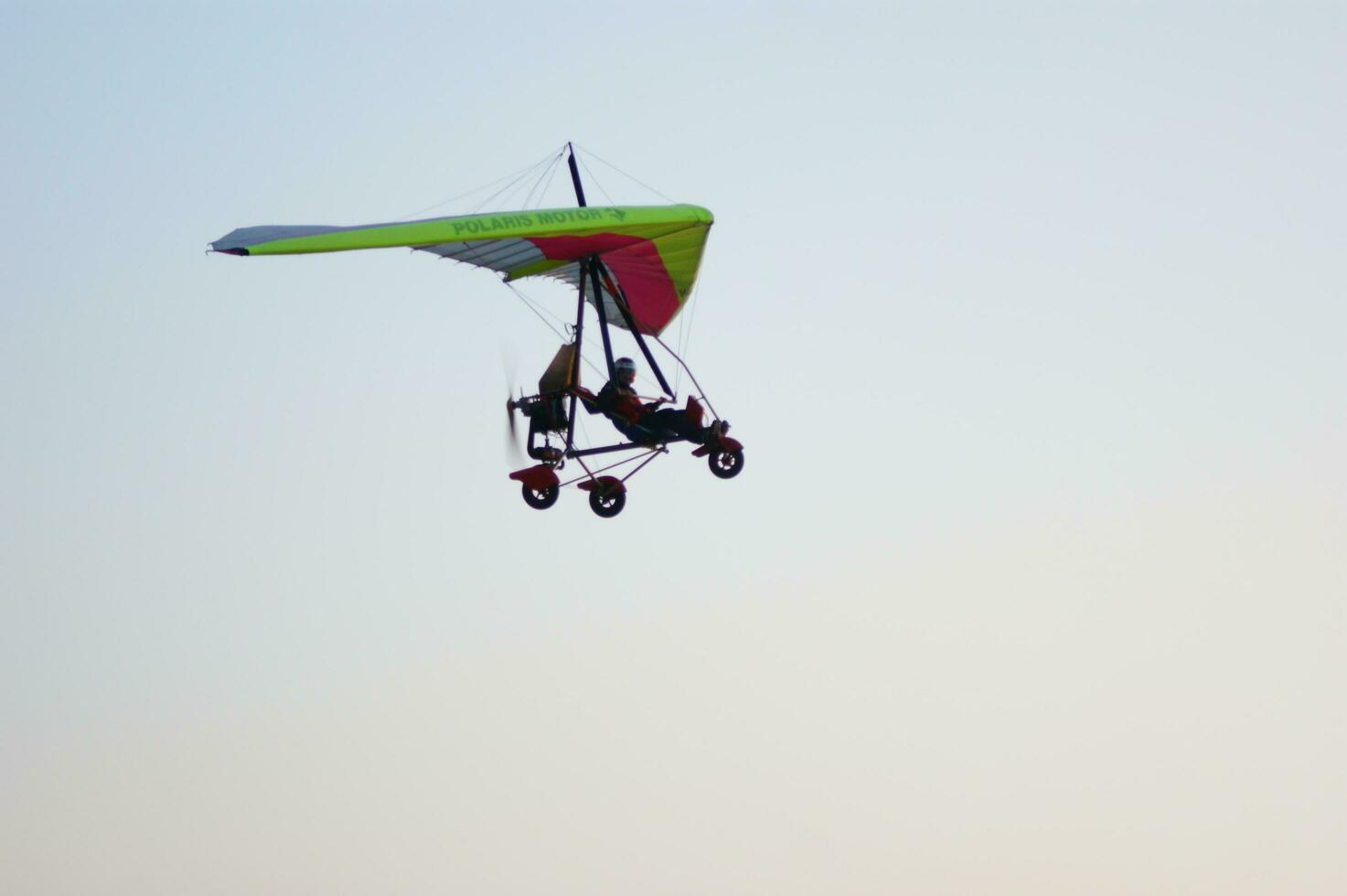 a person flying a hang glider in the sky photo