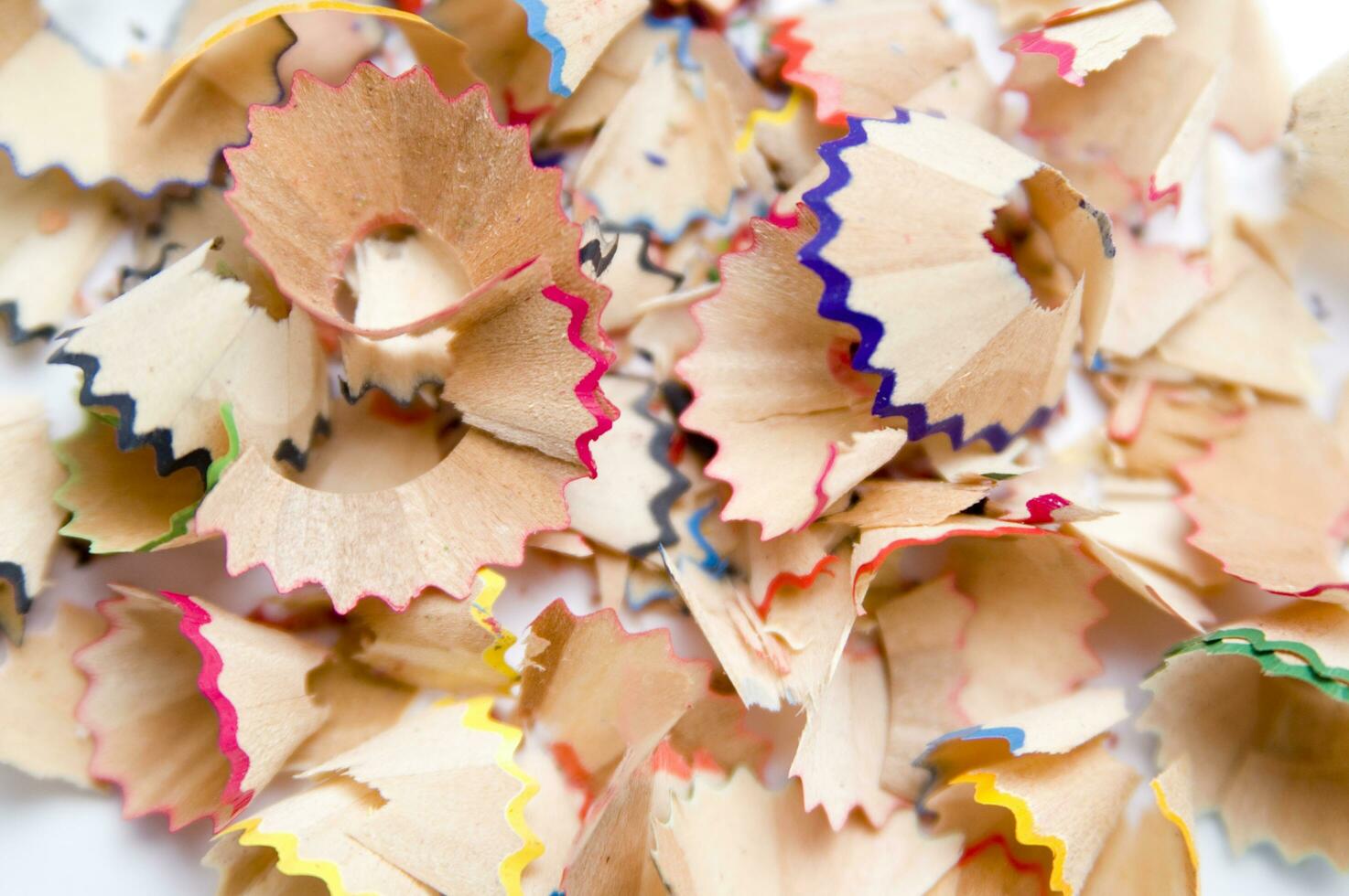 a pile of colored pencils on a white surface photo