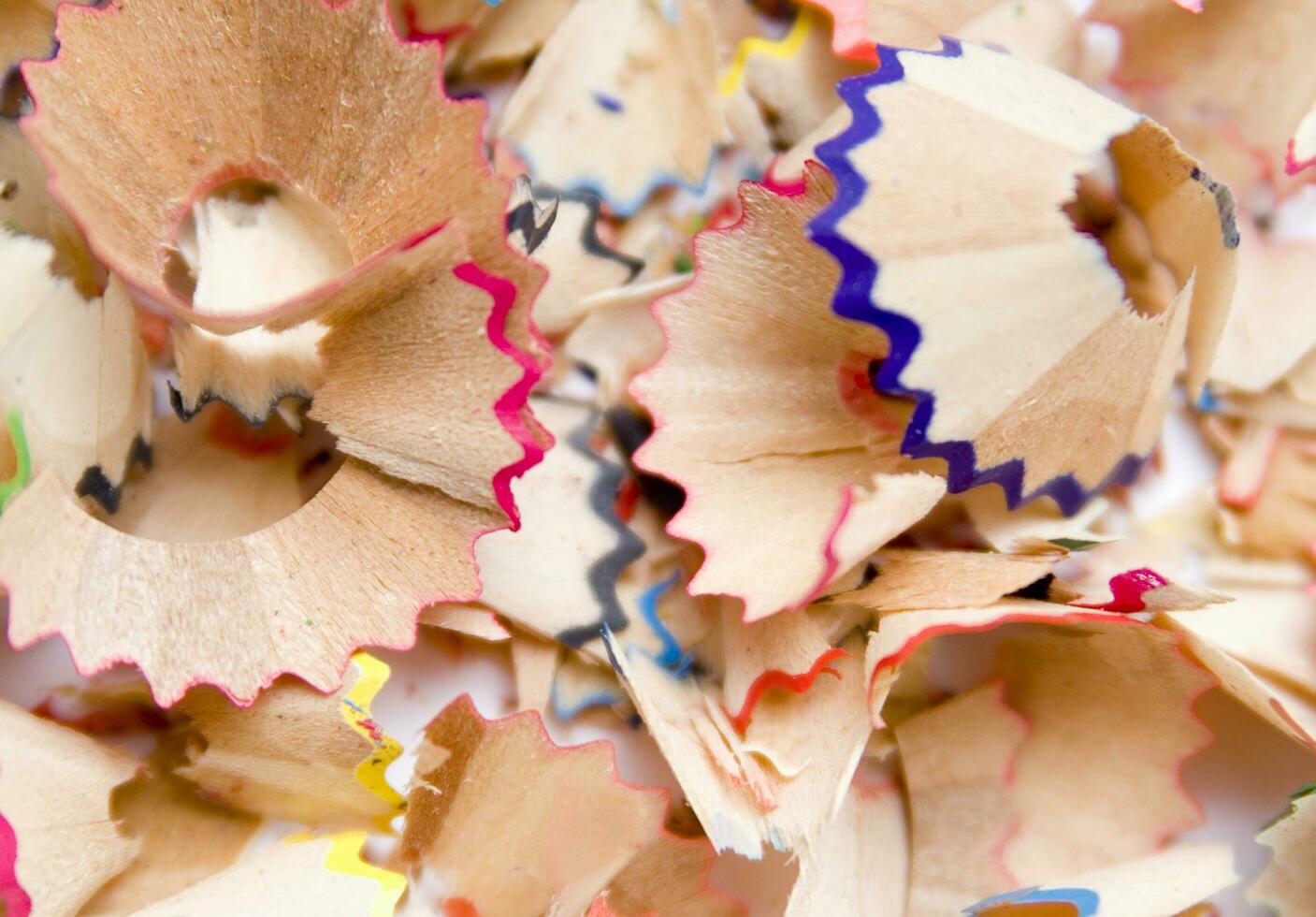 a pile of colored pencils on a white surface photo