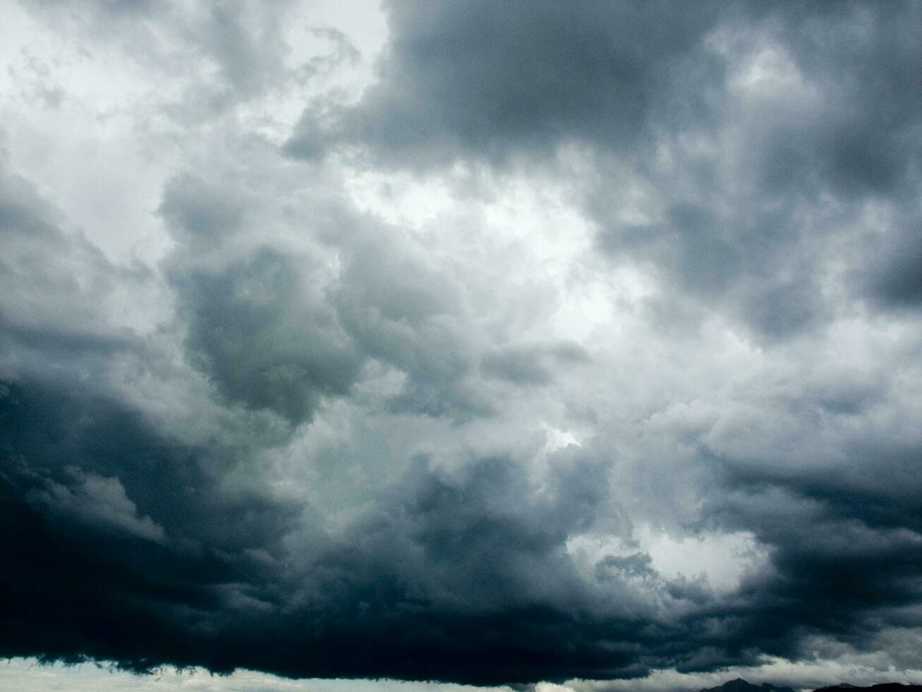 a large dark cloud is seen over a body of water photo
