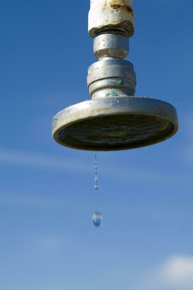 a water pipe with a drop of water on it photo