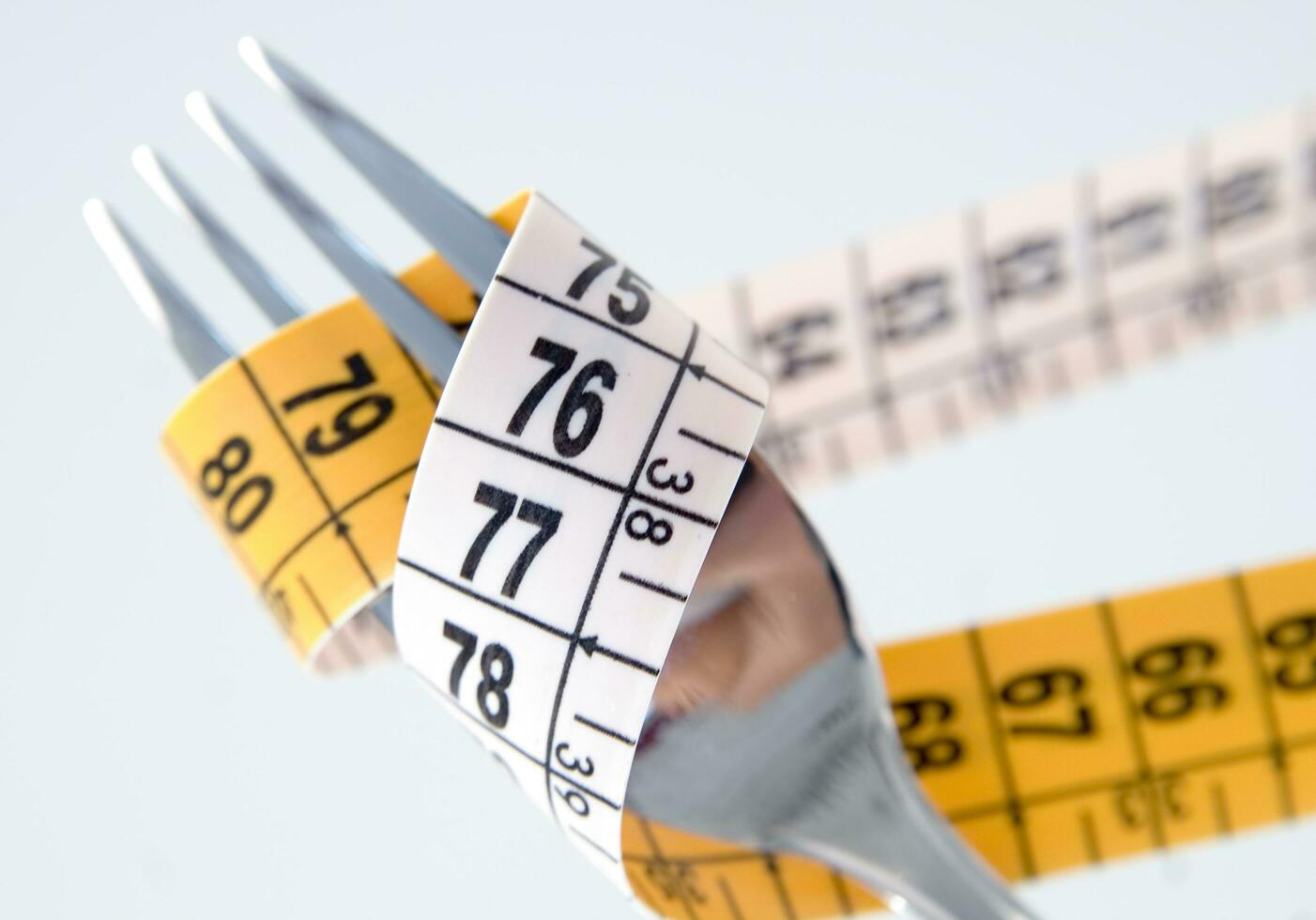 a fork and knife surrounded by measuring tape photo