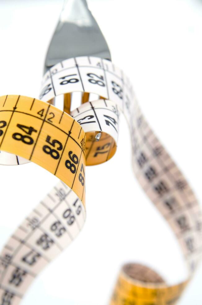 a fork and knife surrounded by measuring tape photo