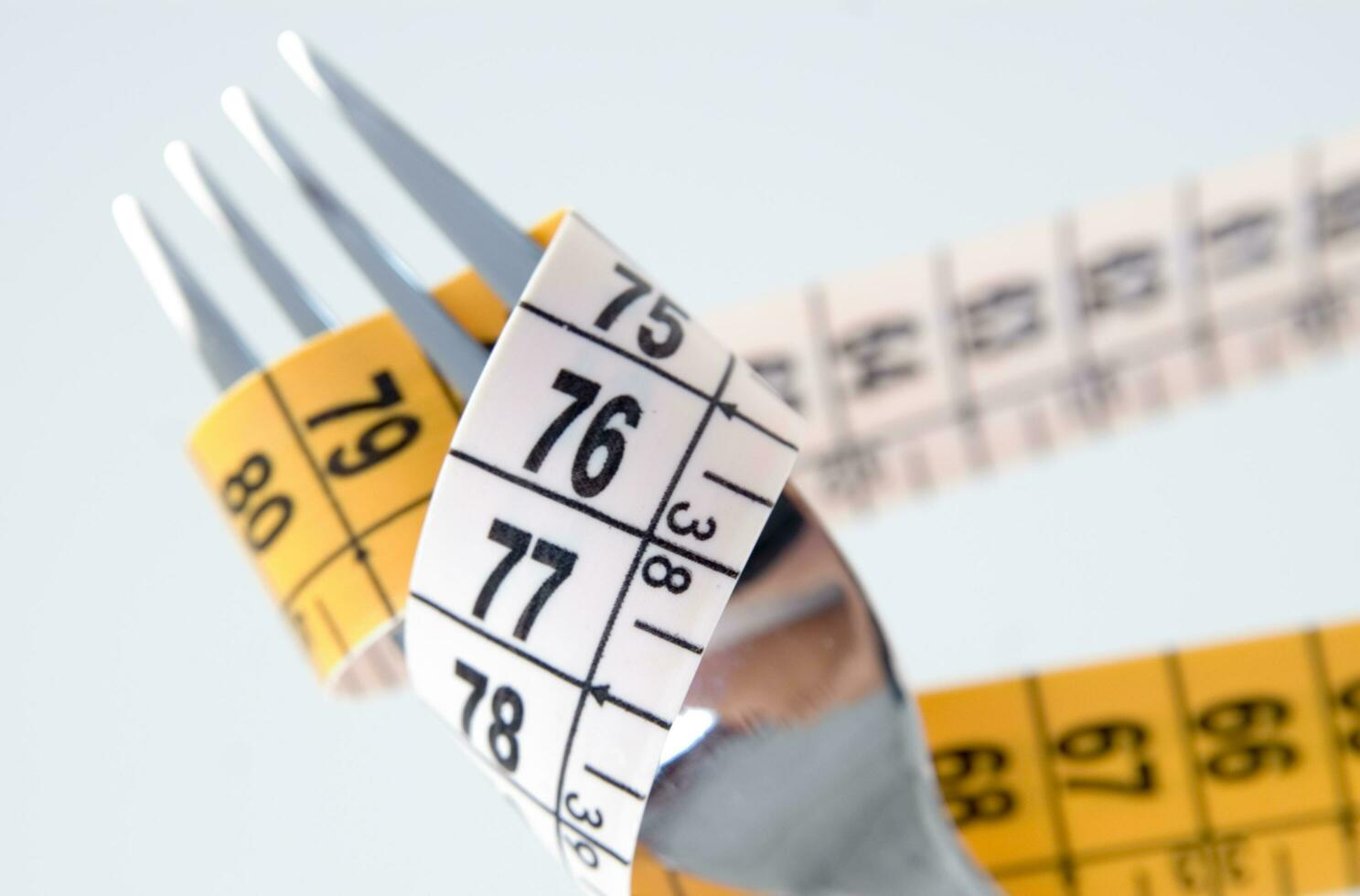 a fork and knife surrounded by measuring tape photo