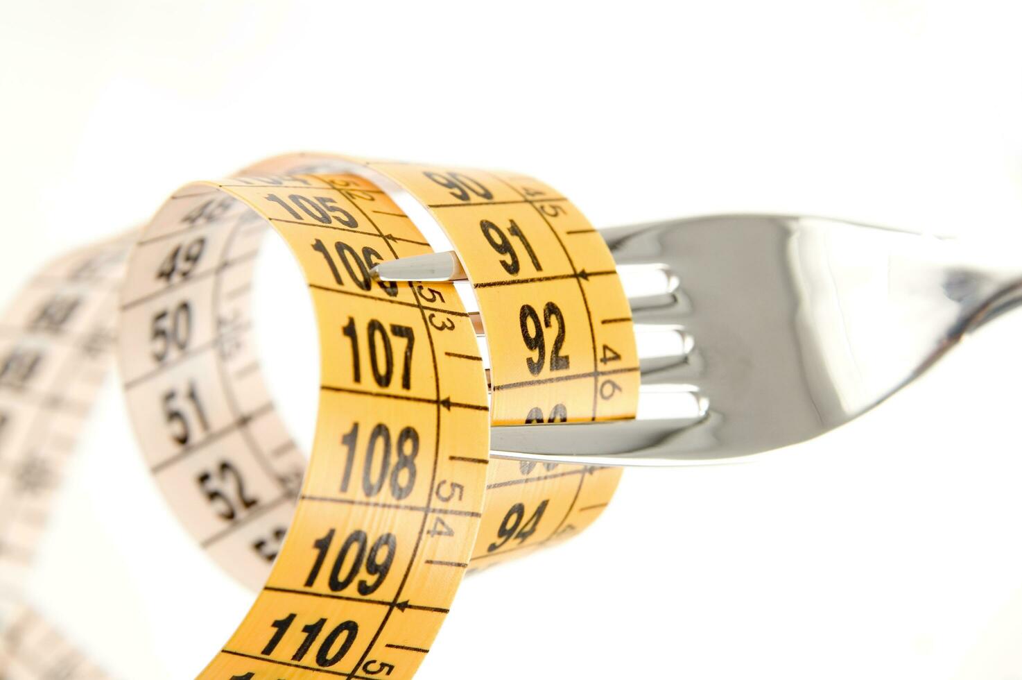 a fork and knife surrounded by measuring tape photo