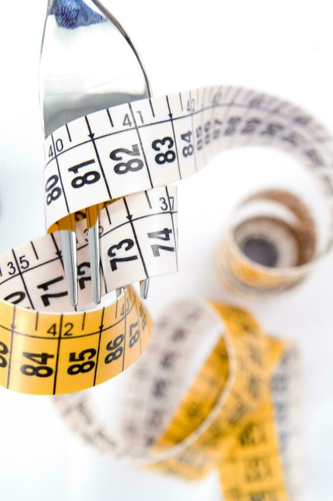 a fork and knife surrounded by measuring tape photo