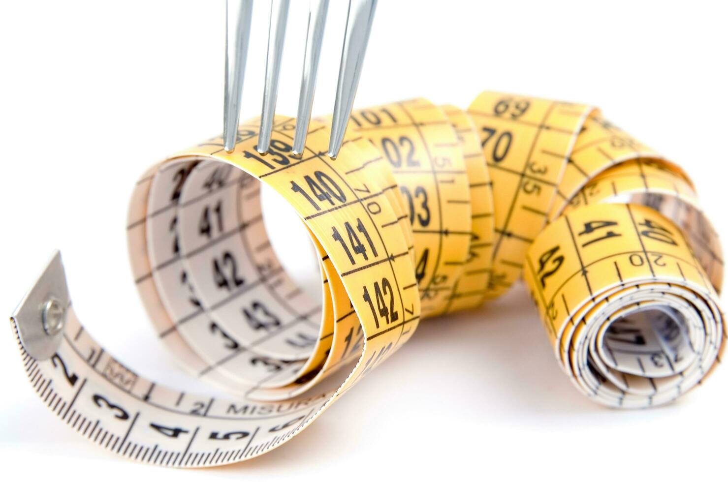 a fork and knife surrounded by measuring tape photo