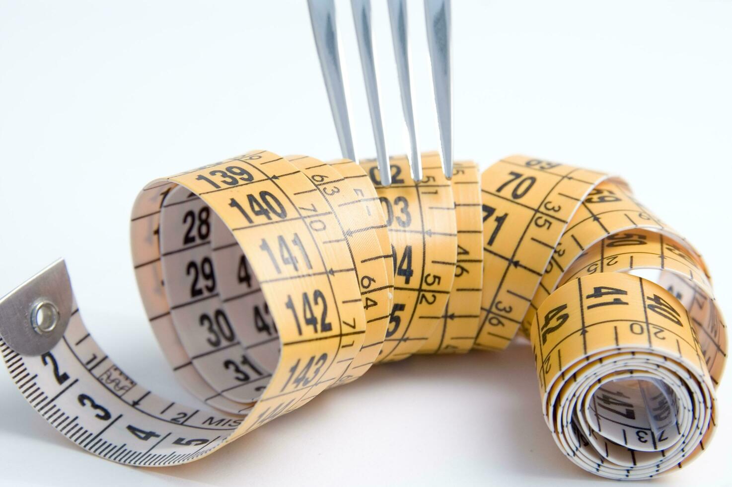 a fork and knife surrounded by measuring tape photo