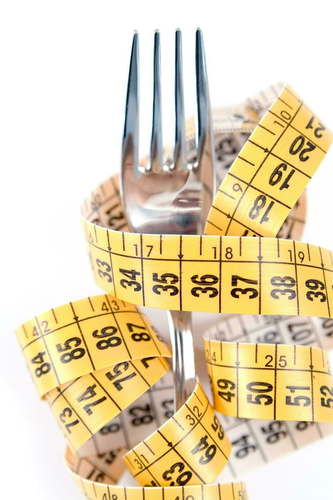 a fork and knife surrounded by measuring tape photo