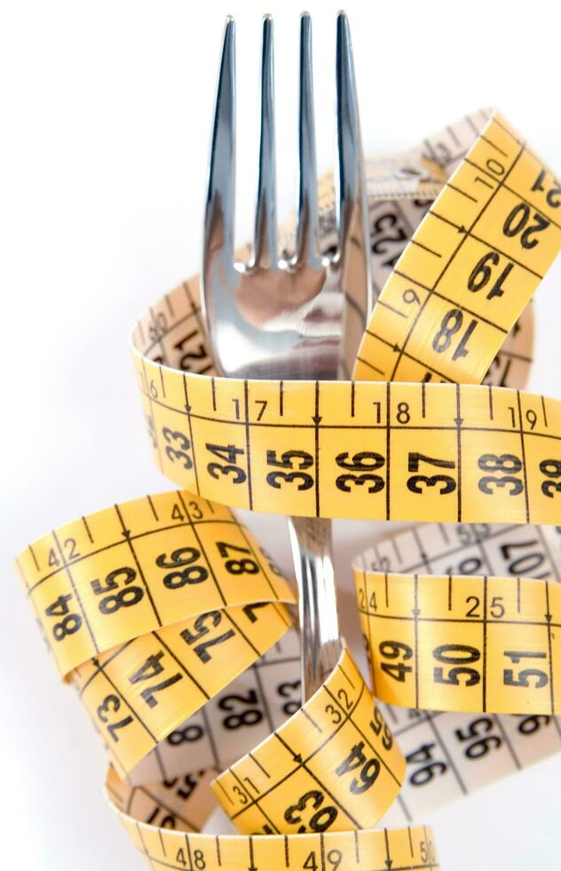 a fork and knife surrounded by measuring tape photo