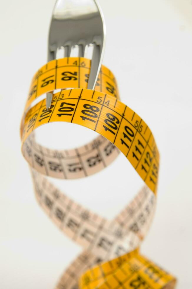 a fork and knife surrounded by measuring tape photo