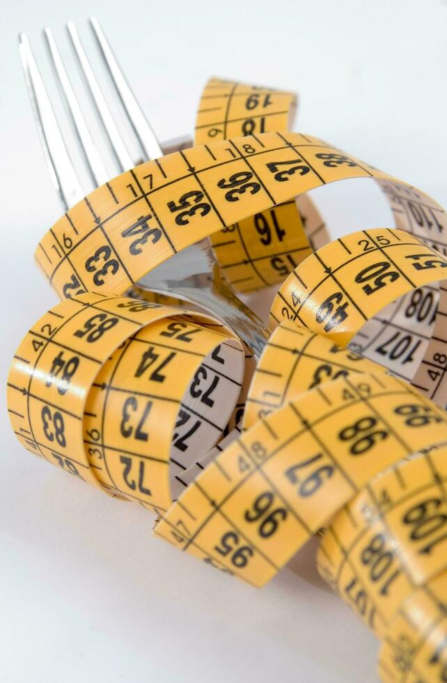 a fork and knife surrounded by measuring tape photo