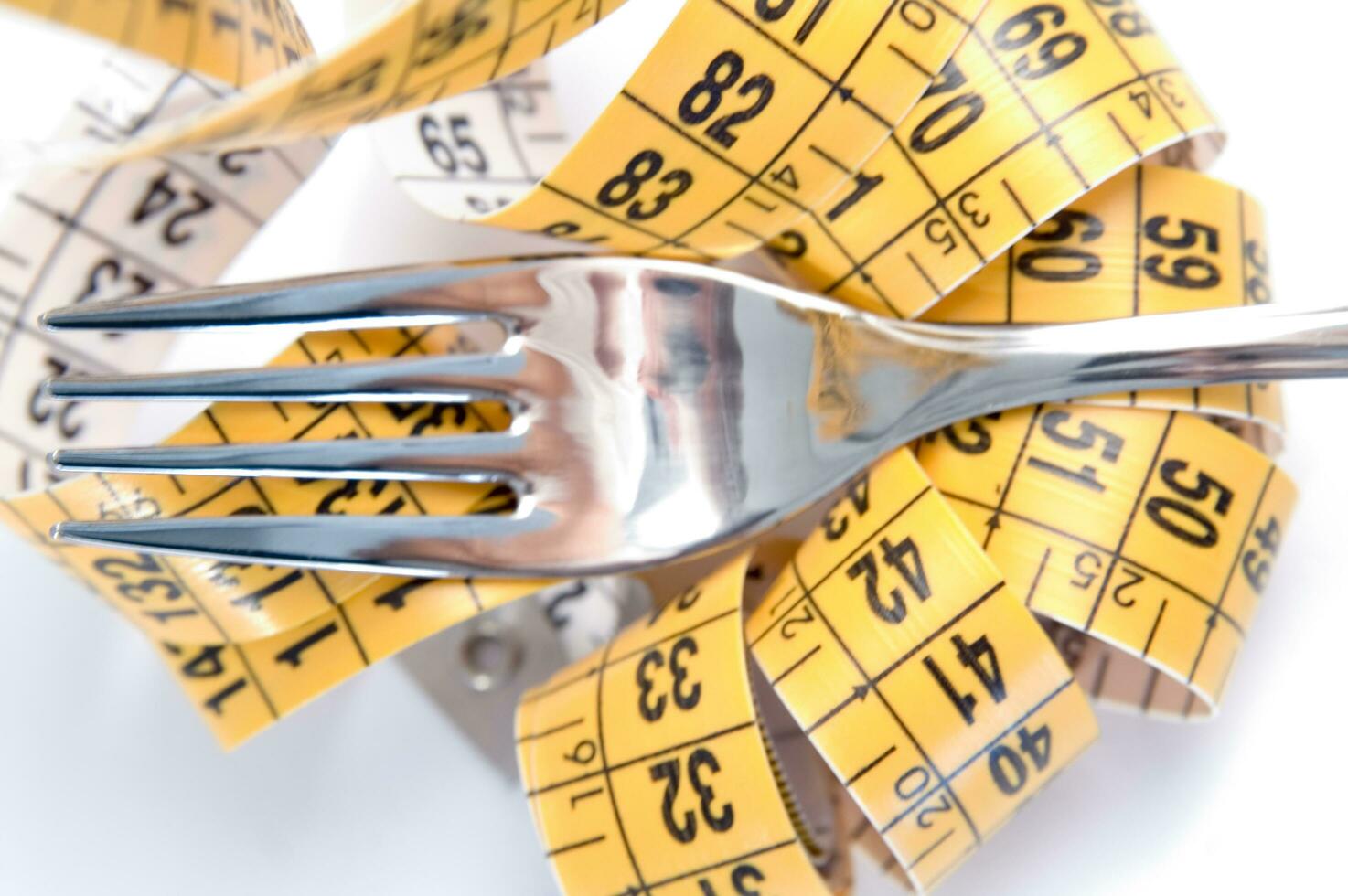 a fork and knife surrounded by measuring tape photo