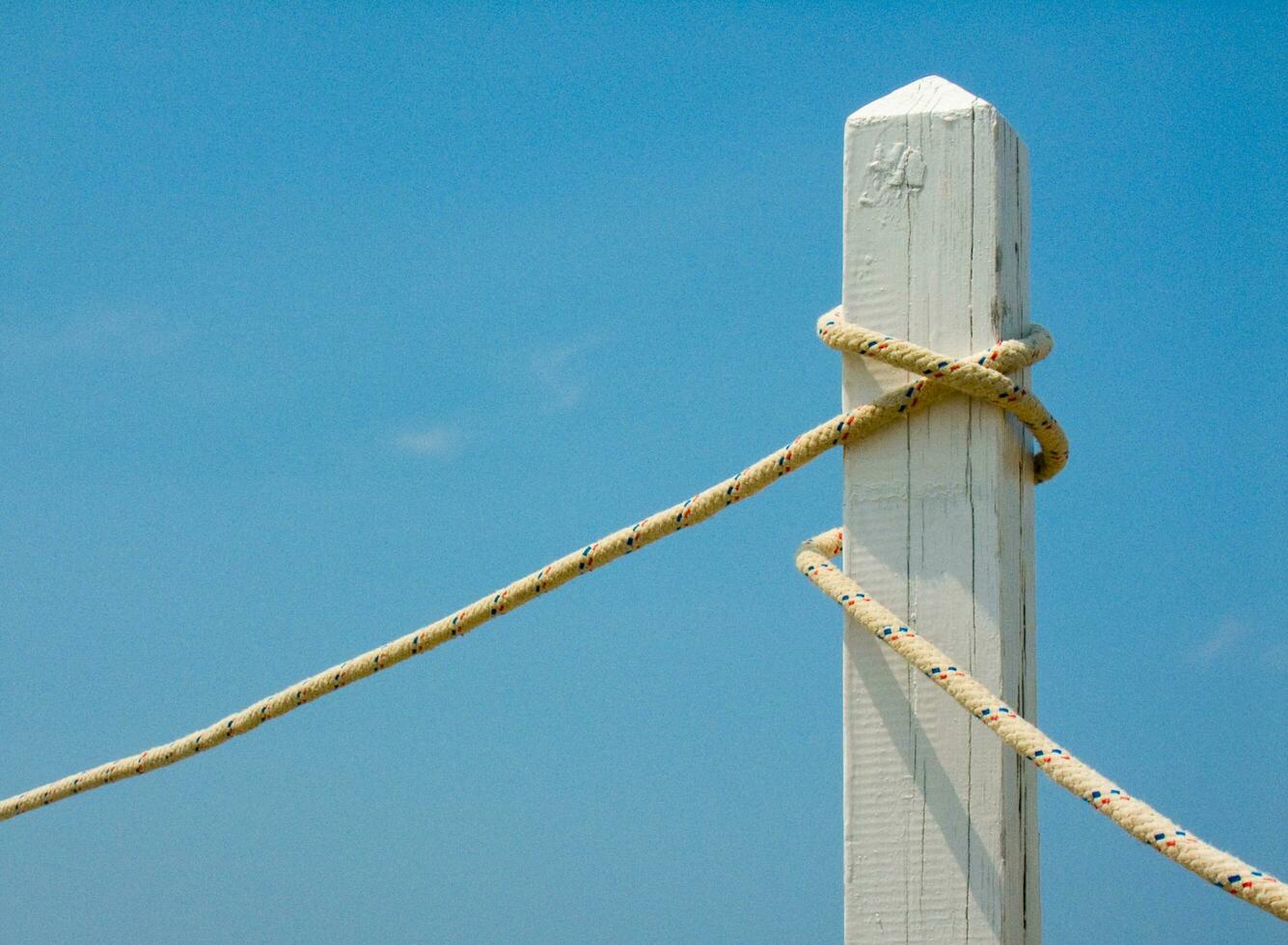 a white post with a rope tied to it photo