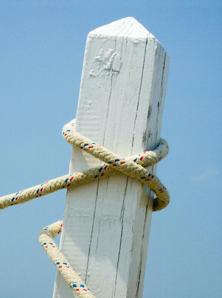 a white post with a rope tied to it photo