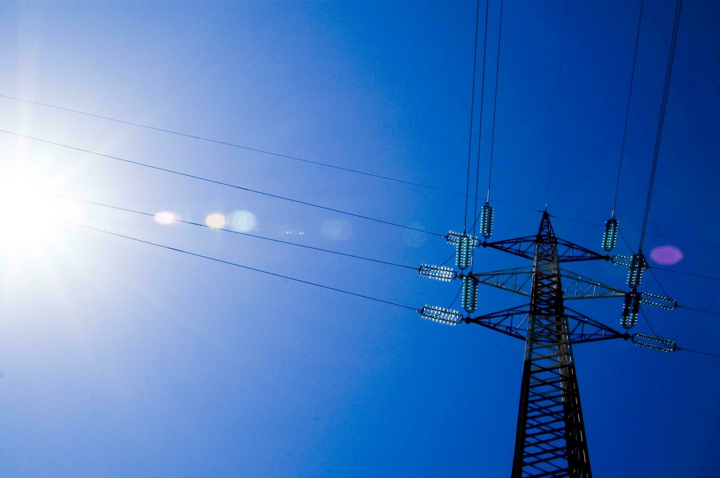 the sun shines through the metal structure of an oil rig photo