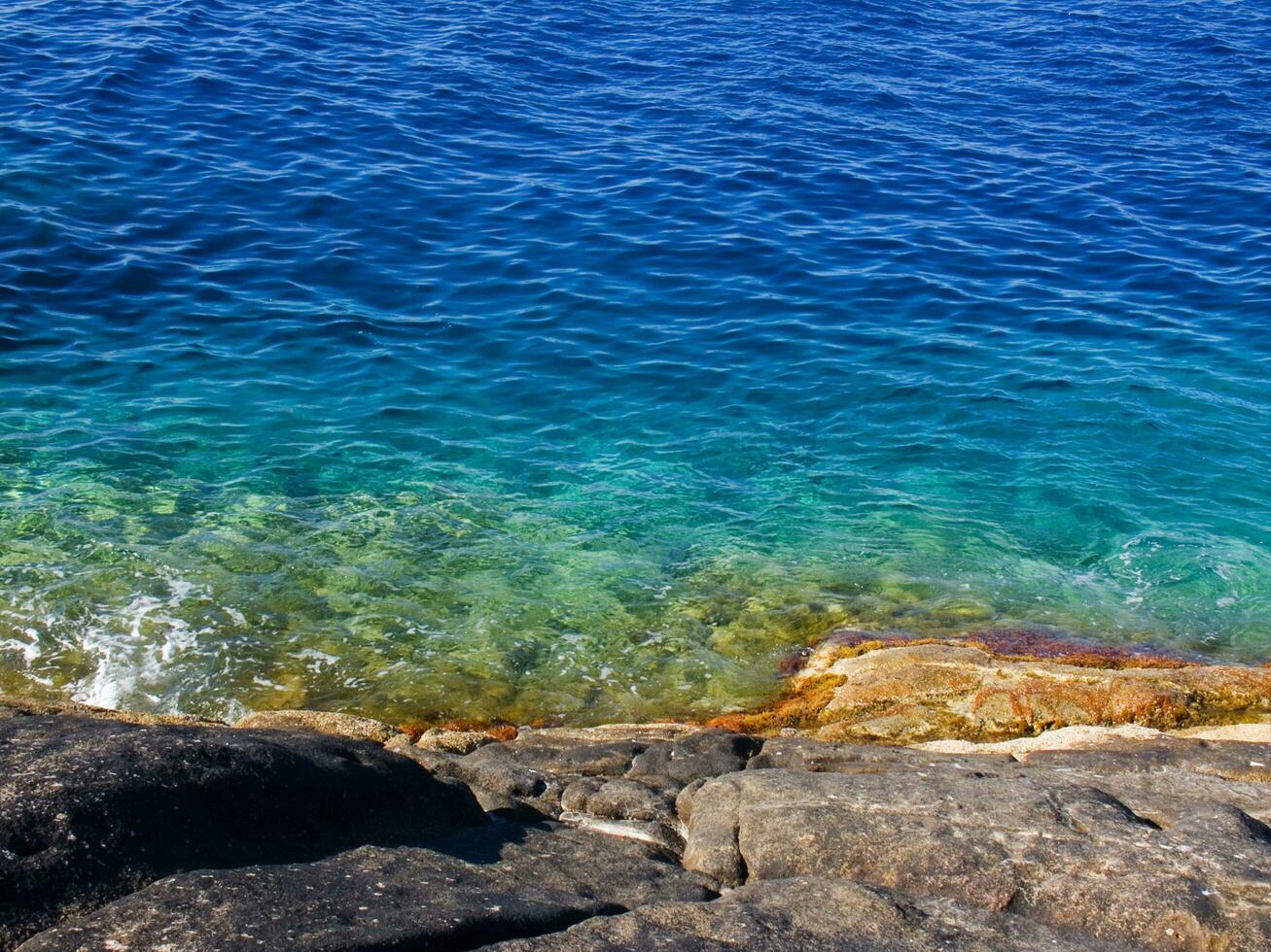 a rocky shore with waves crashing against the rocks photo