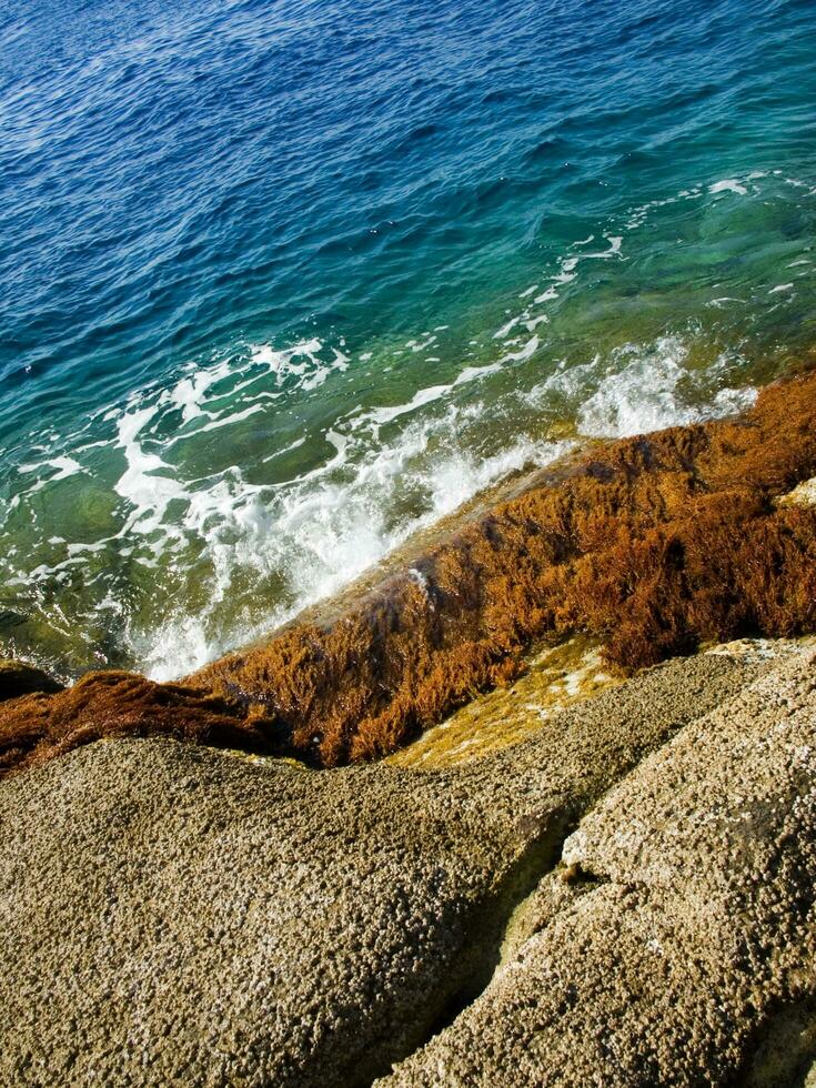 a rocky shore with waves crashing against the rocks photo
