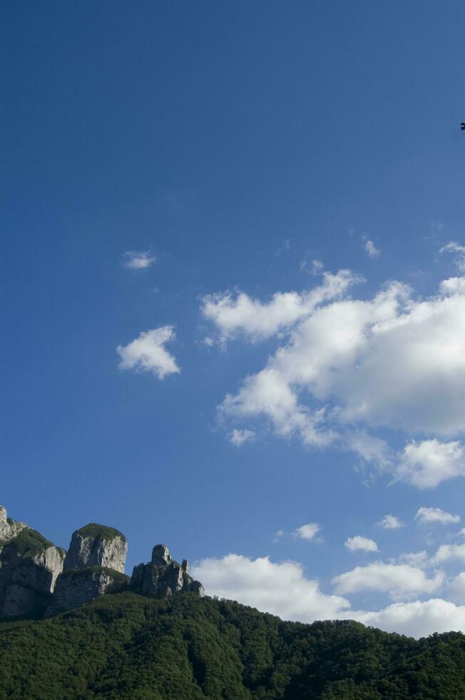 un montaña rango con un pocos casas en parte superior foto