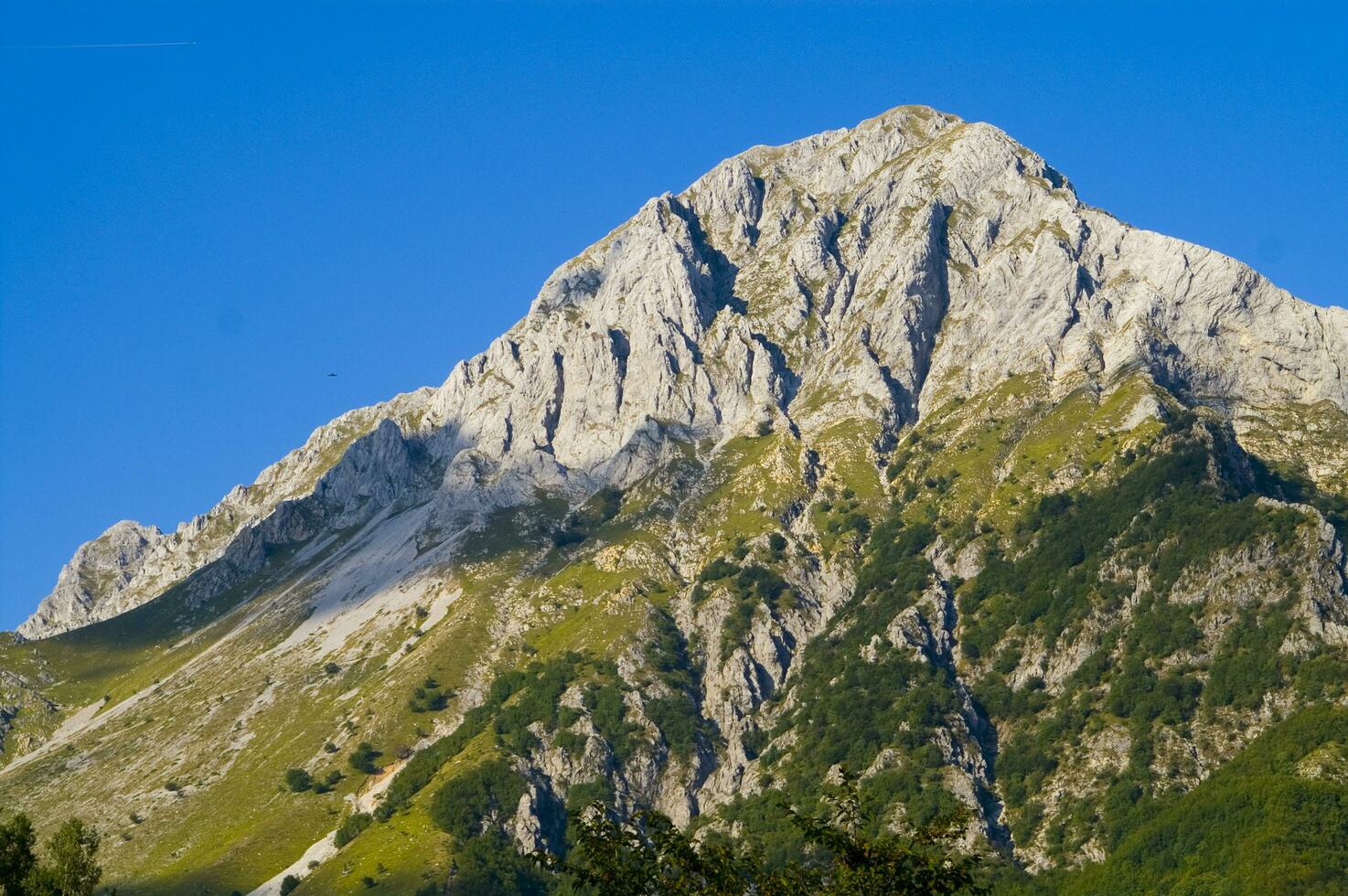 un montaña rango con un pocos casas en parte superior foto