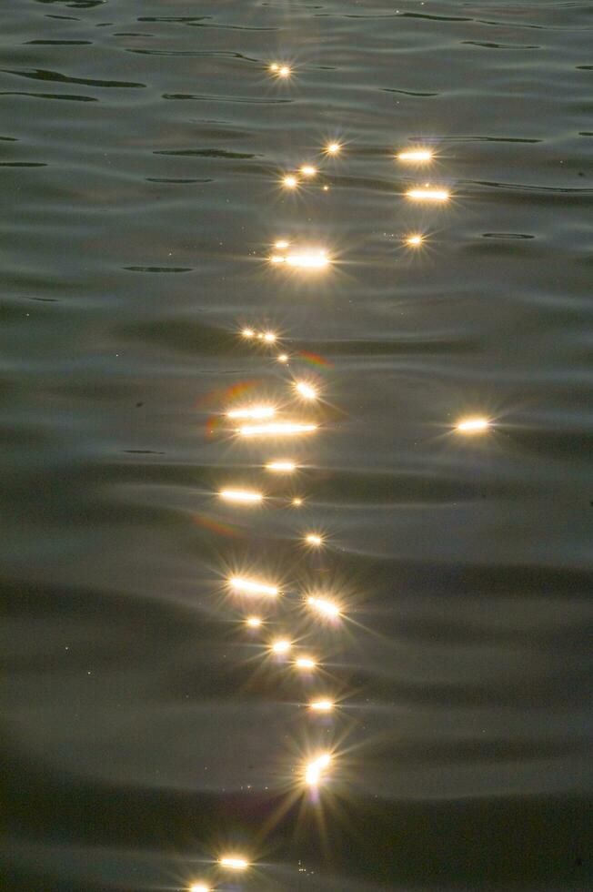 un barco es en el agua a puesta de sol foto