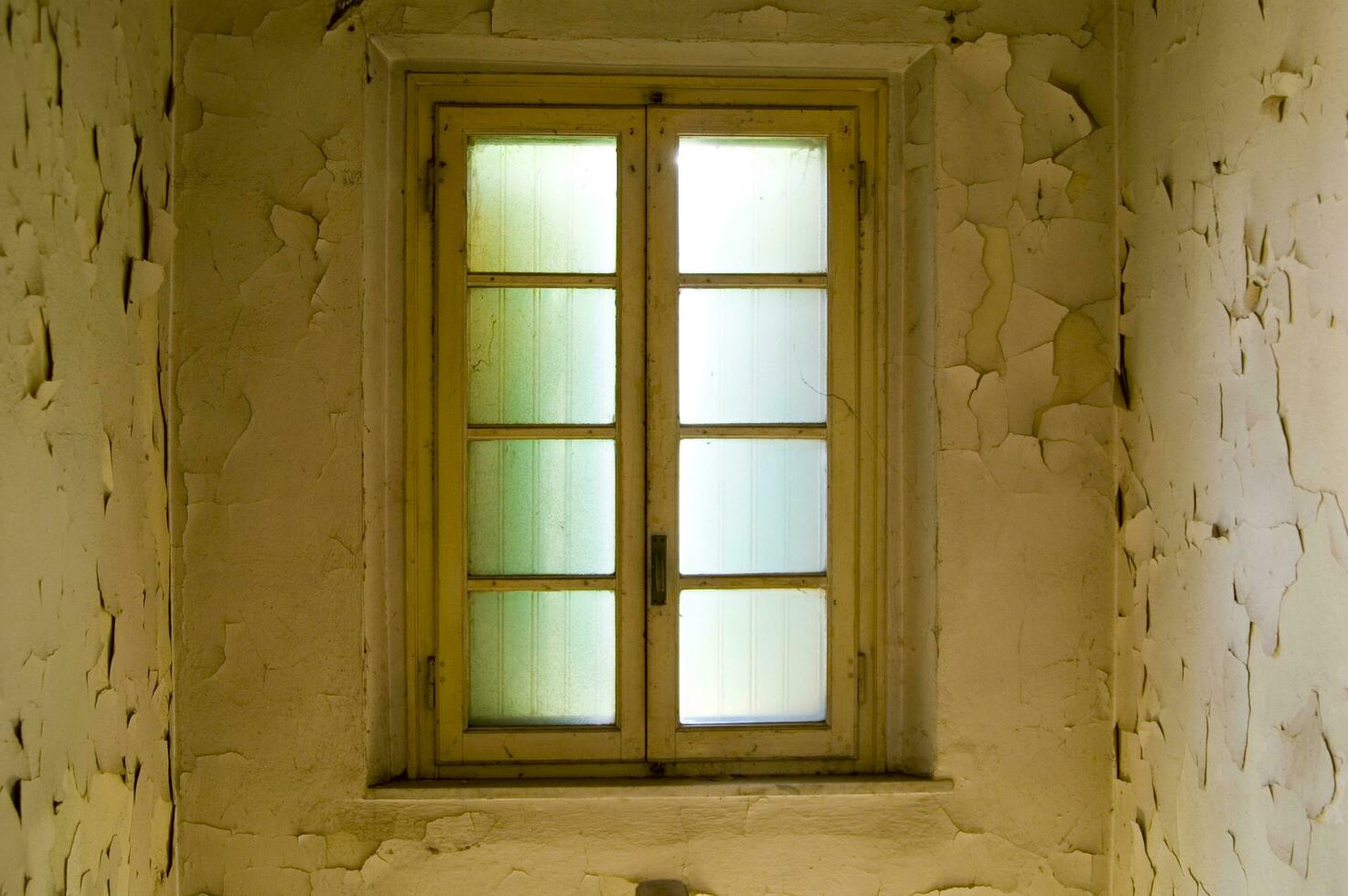 a window in a room with peeling paint photo