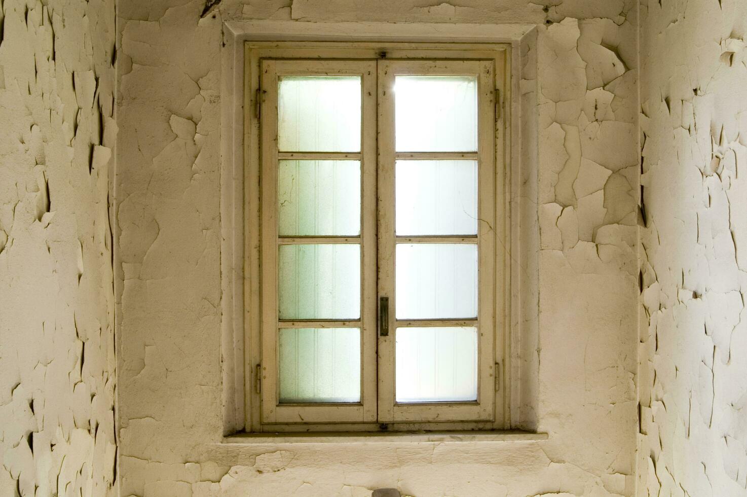 a window in a room with peeling paint photo