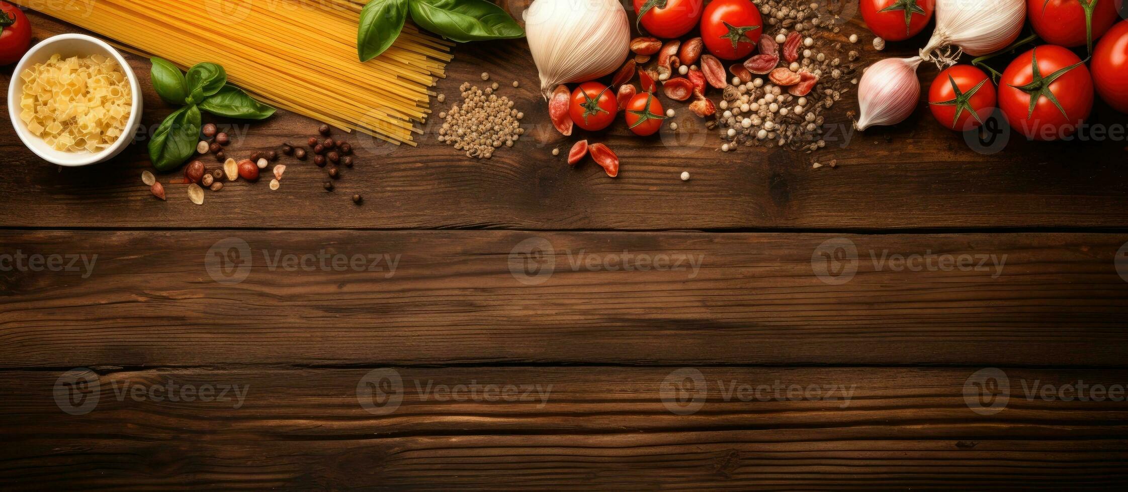 Top view of pasta cooking ingredients on a wooden kitchen table, with space available for your photo