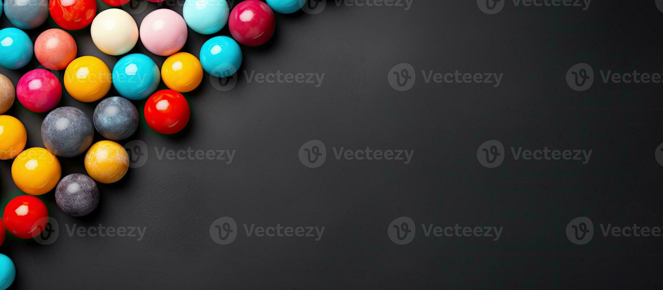 Colorful candy balls placed on a gray and black paper background, arranged as a horizontal banner photo