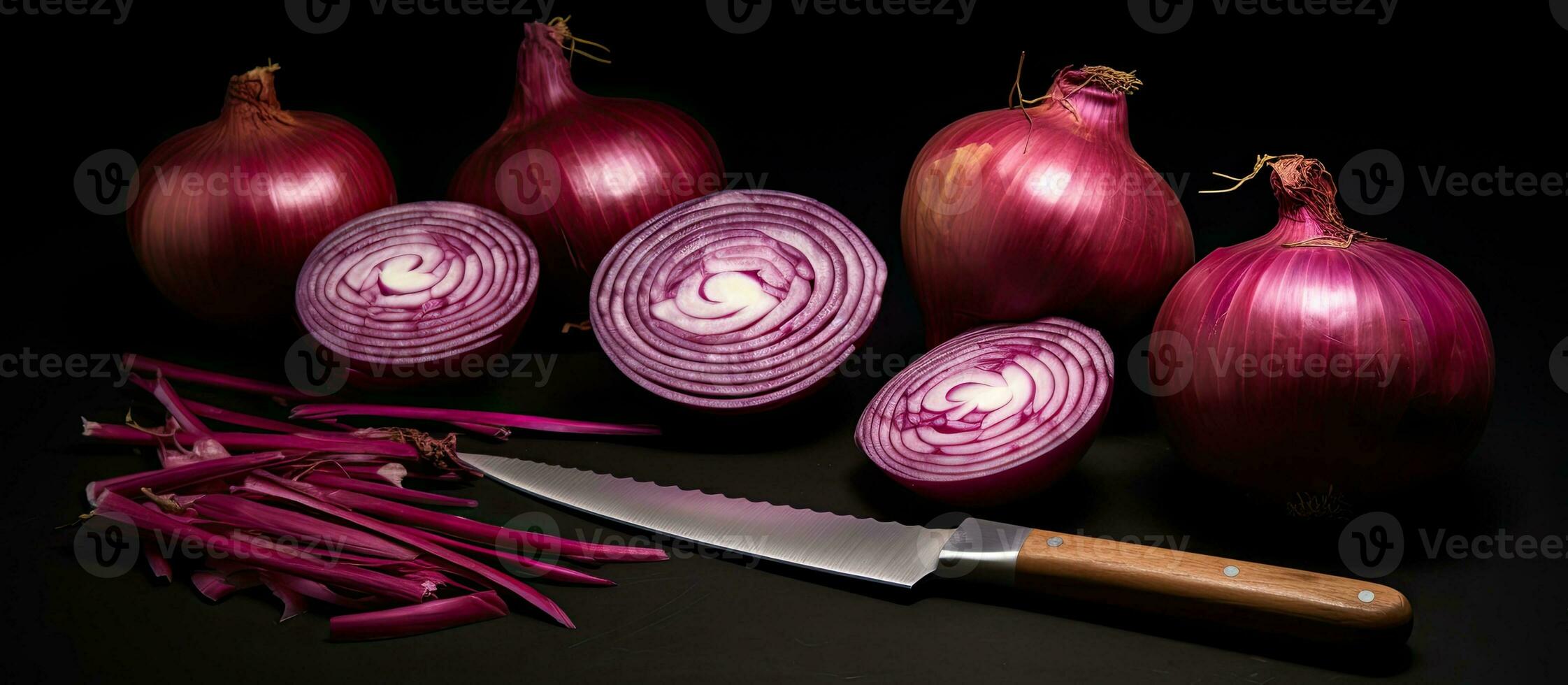 A photograph of red onions, both whole and sliced, along with a knife, set against a black background. photo