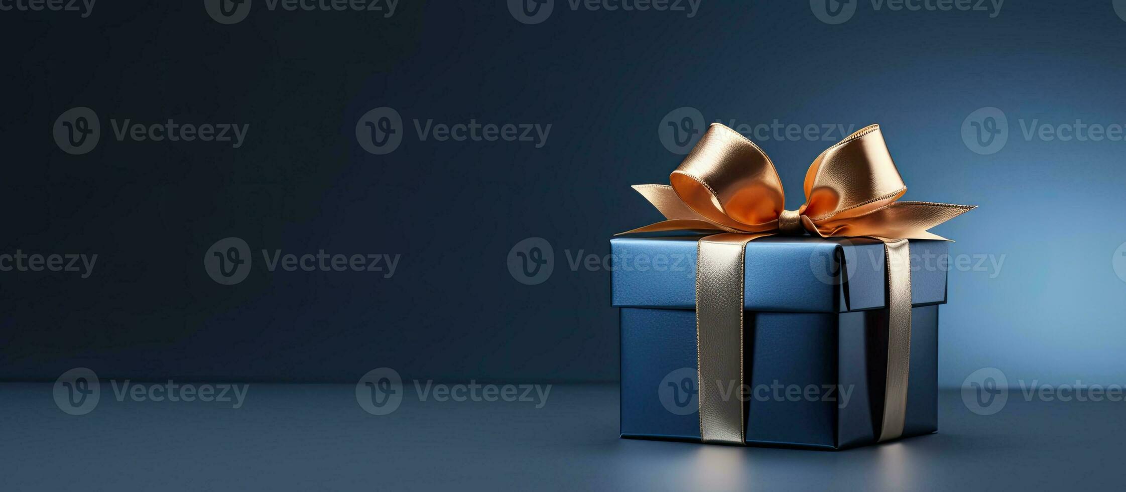 side view monochrome image of a small luxury gift box with a blue bow on a dark blue background. photo