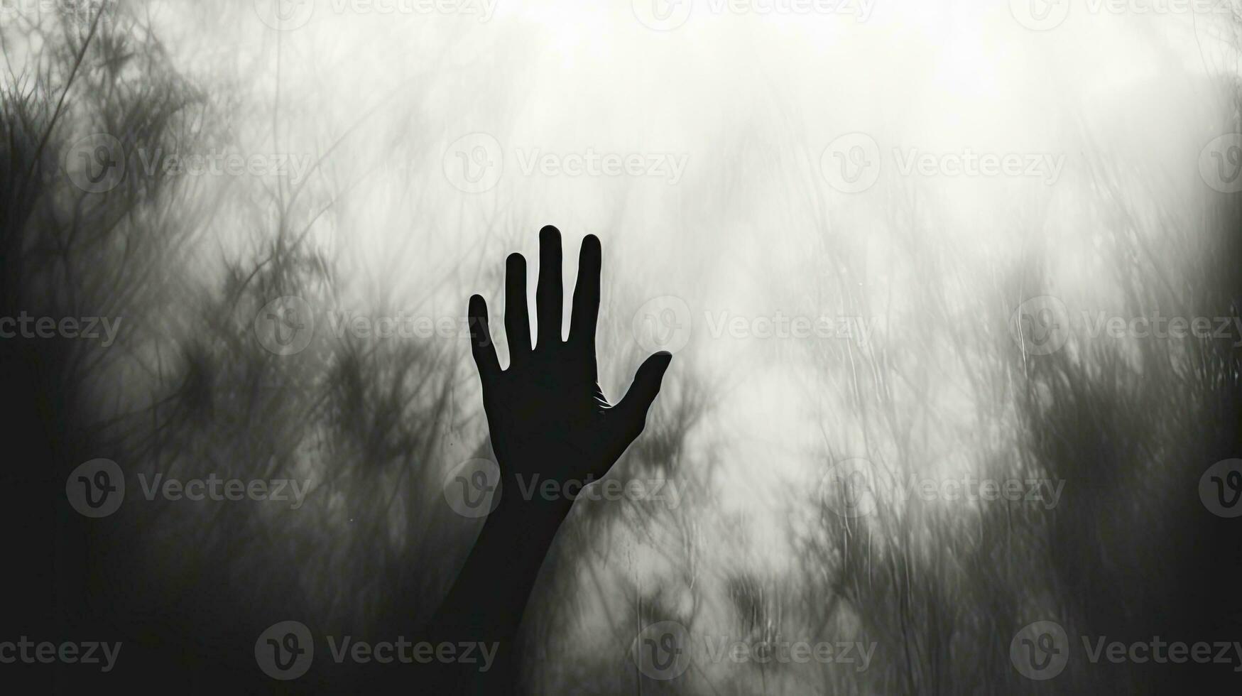 Silhouetted hand behind frosted glass Halloween theme photo