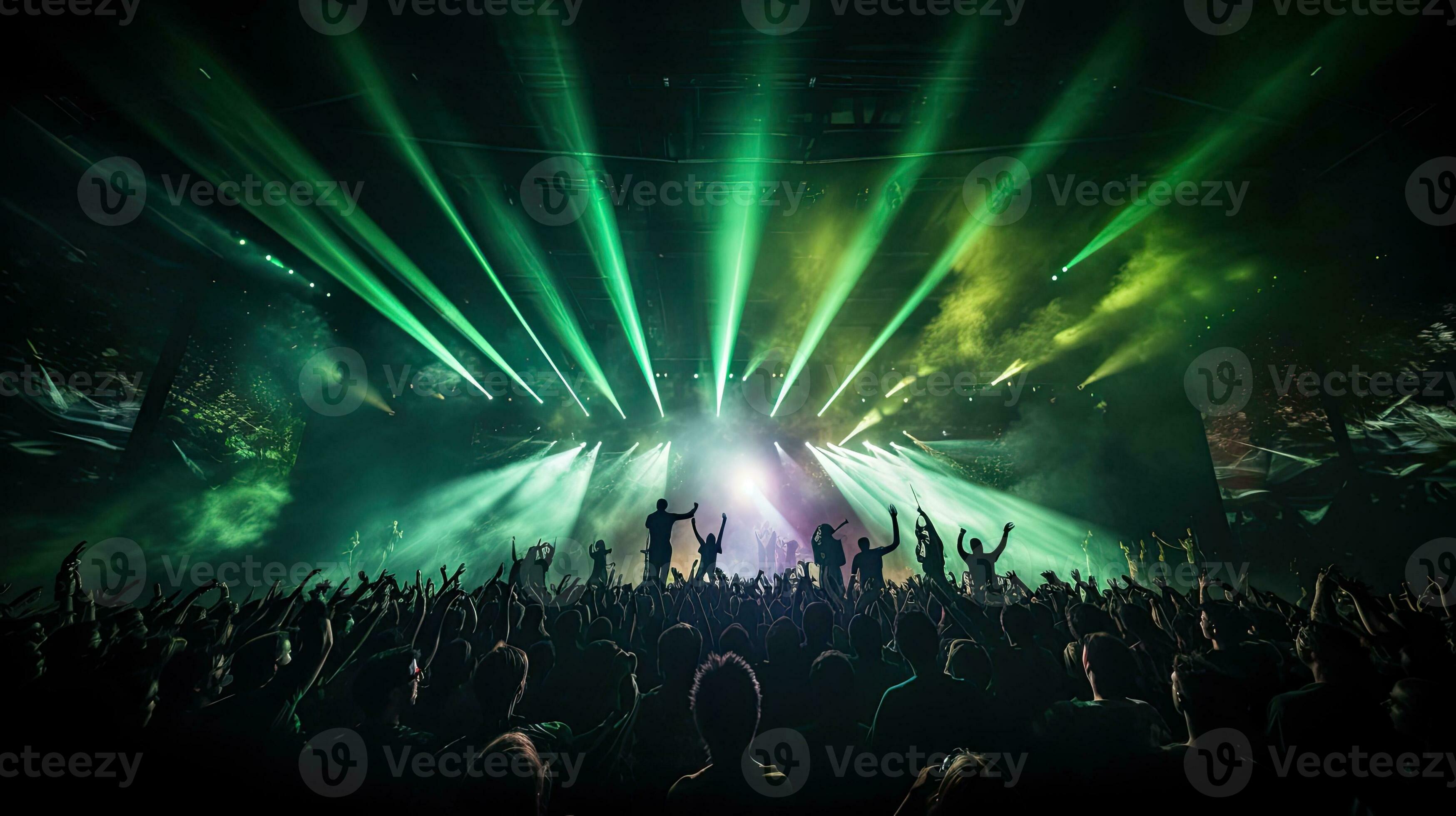 Crowded concert hall with green stage lights rock show people