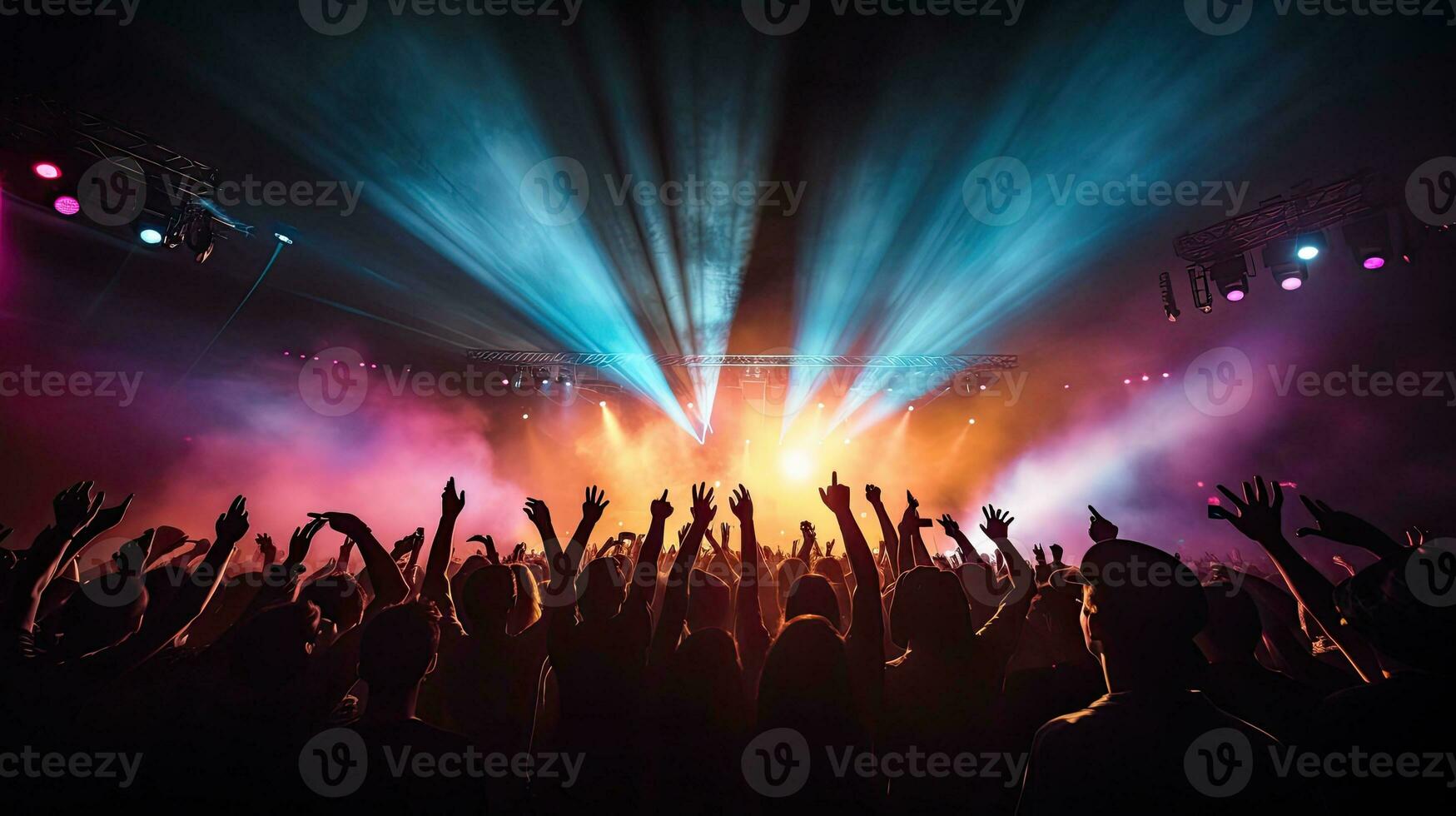 Cheering crowd illuminated by vibrant stage lights at concert photo