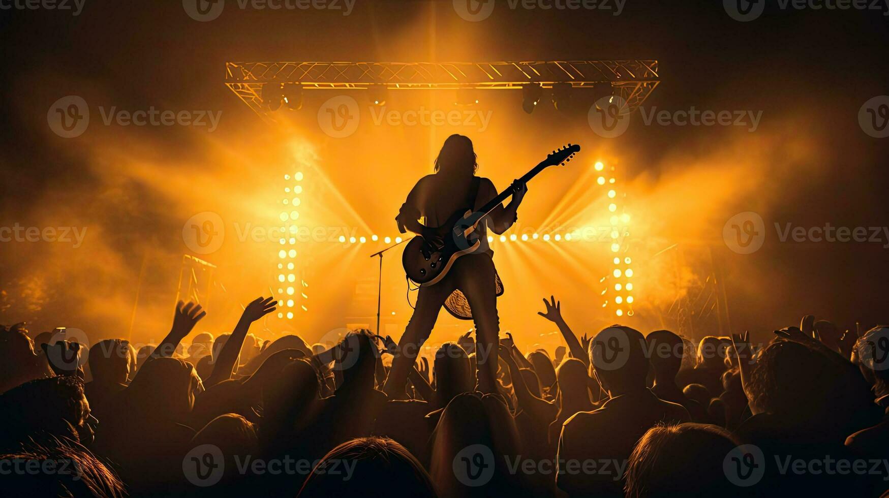 Guitar player performing on stage with crowd in front photo