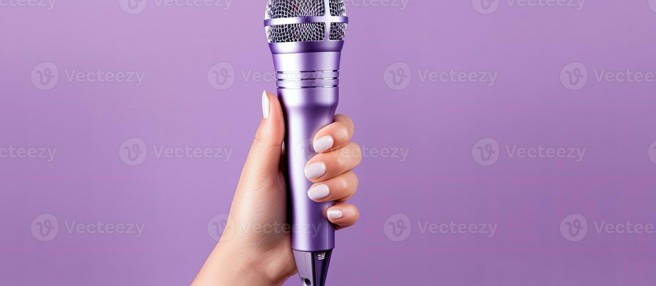 A lilac background with a woman s hand holding a microphone photo