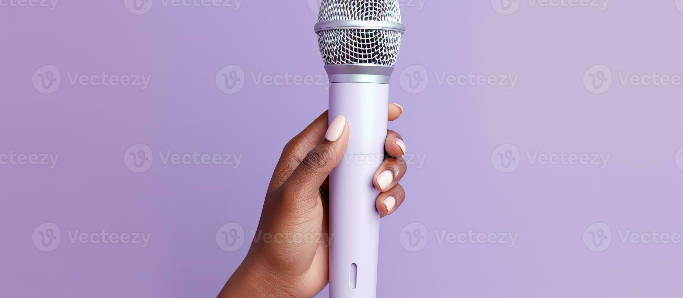 A lilac background with a woman s hand holding a microphone photo