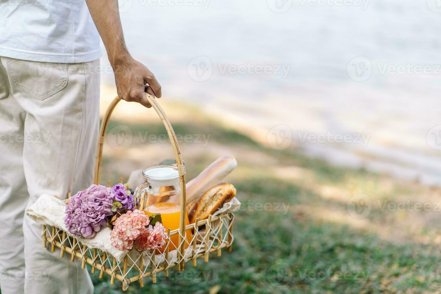 Pareja caminando en jardín con picnic cesta. en amor Pareja es disfrutando picnic hora en parque al aire libre foto