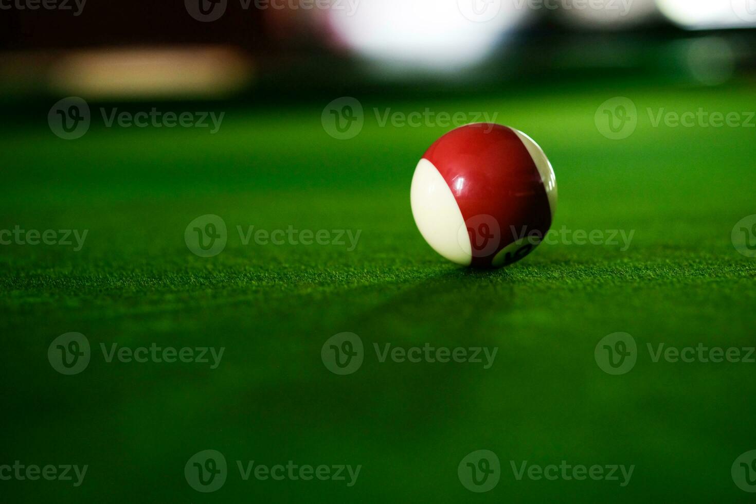 Man's hand and Cue arm playing snooker game or preparing aiming to shoot pool balls on a green billiard table. Colorful snooker balls on green frieze. photo