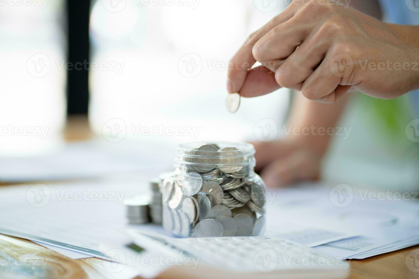 Saving money. Businessman Accountant verify growing business and saving money stacking coins with calculator. Accountancy Concept. photo