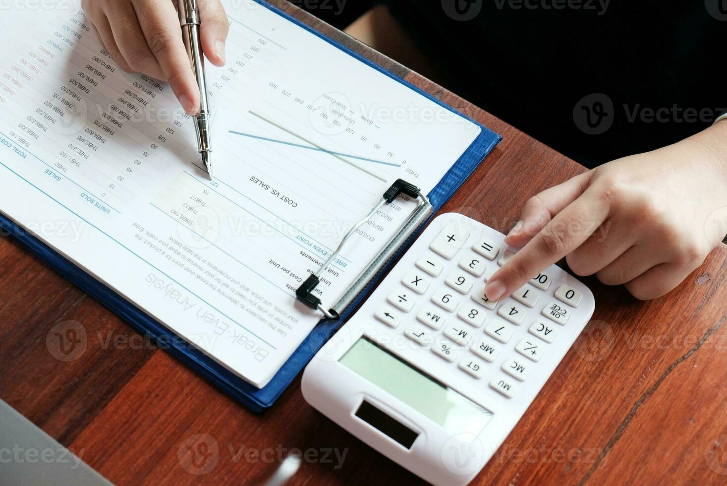 Businessman analyzing investment charts and pressing calculator buttons over documents. Accounting Concept. photo