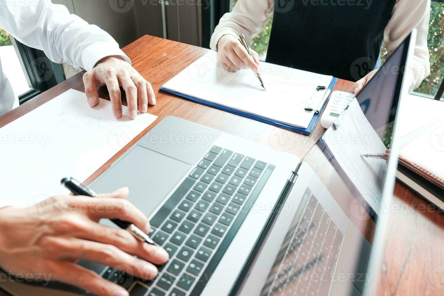 Businessman analyzing investment charts and pressing calculator buttons over documents. Accounting Concept. photo
