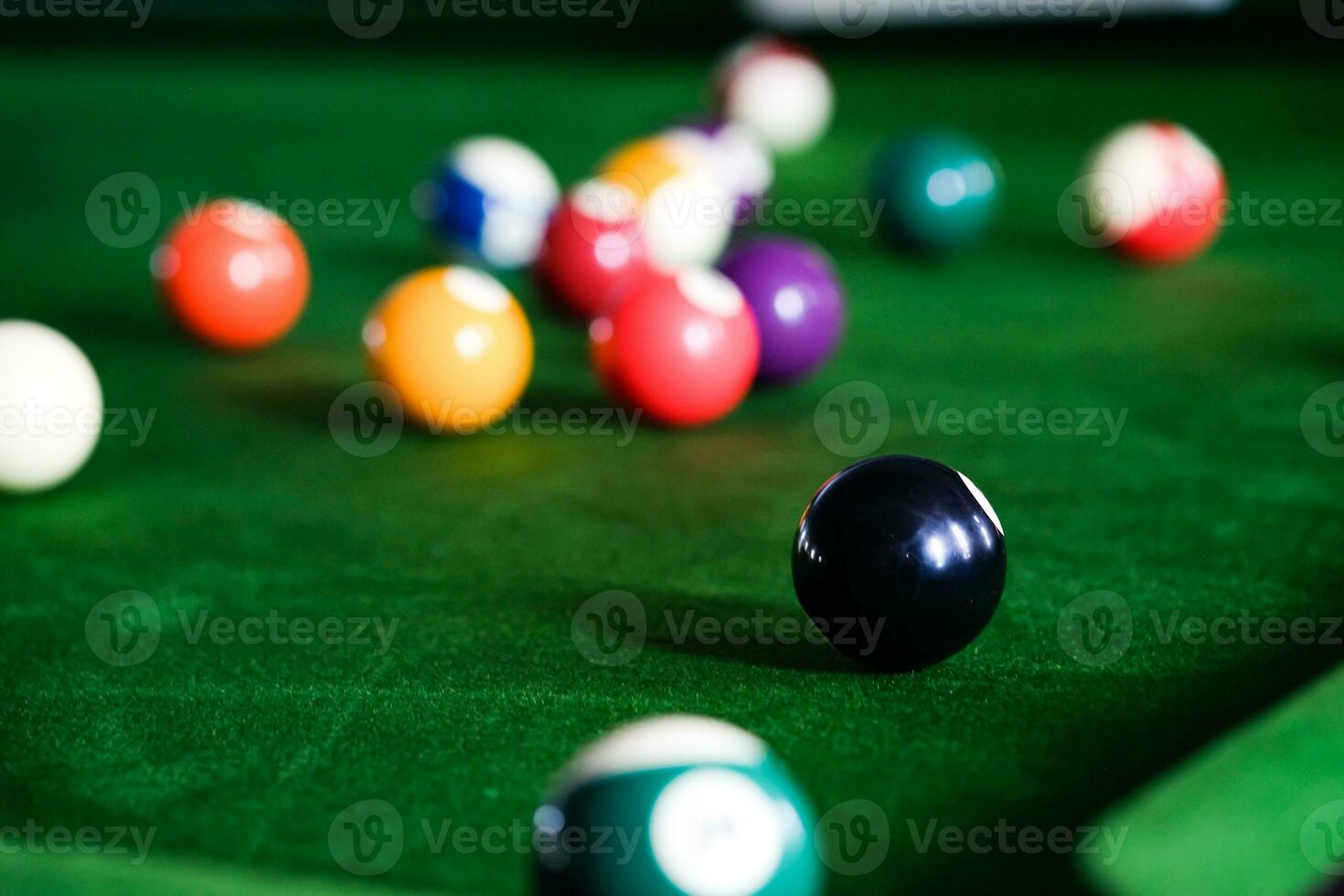 Man's hand and Cue arm playing snooker game or preparing aiming to shoot pool balls on a green billiard table. Colorful snooker balls on green frieze. photo