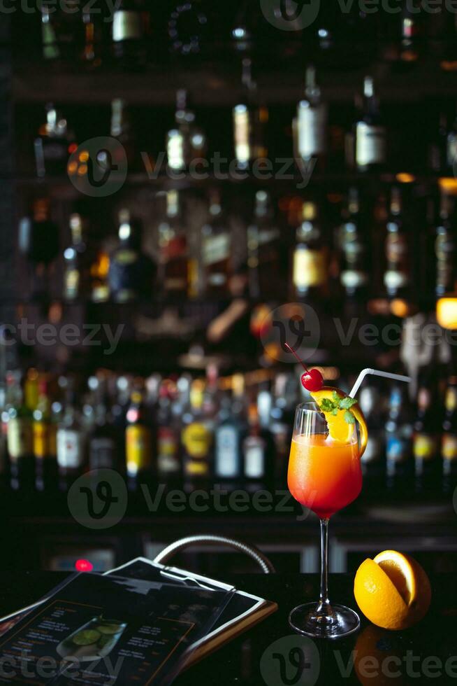 Cocktail alcoholic drink with Classic bar counter with bottles in blurred liquor bar background photo