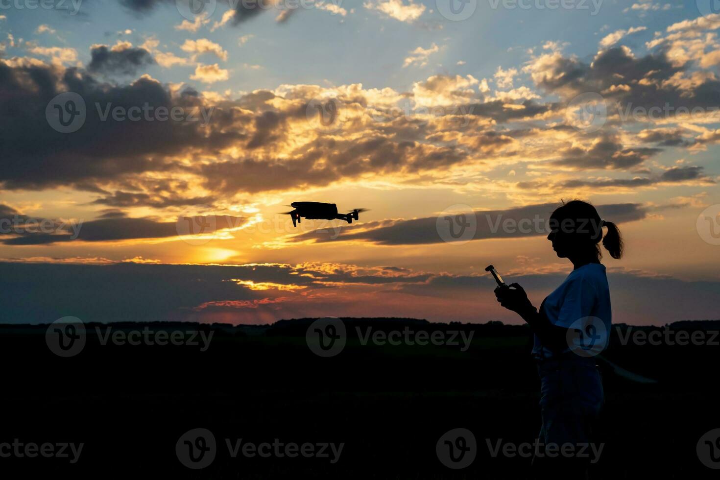 silueta de mujer controlador zumbido en puesta de sol antecedentes foto