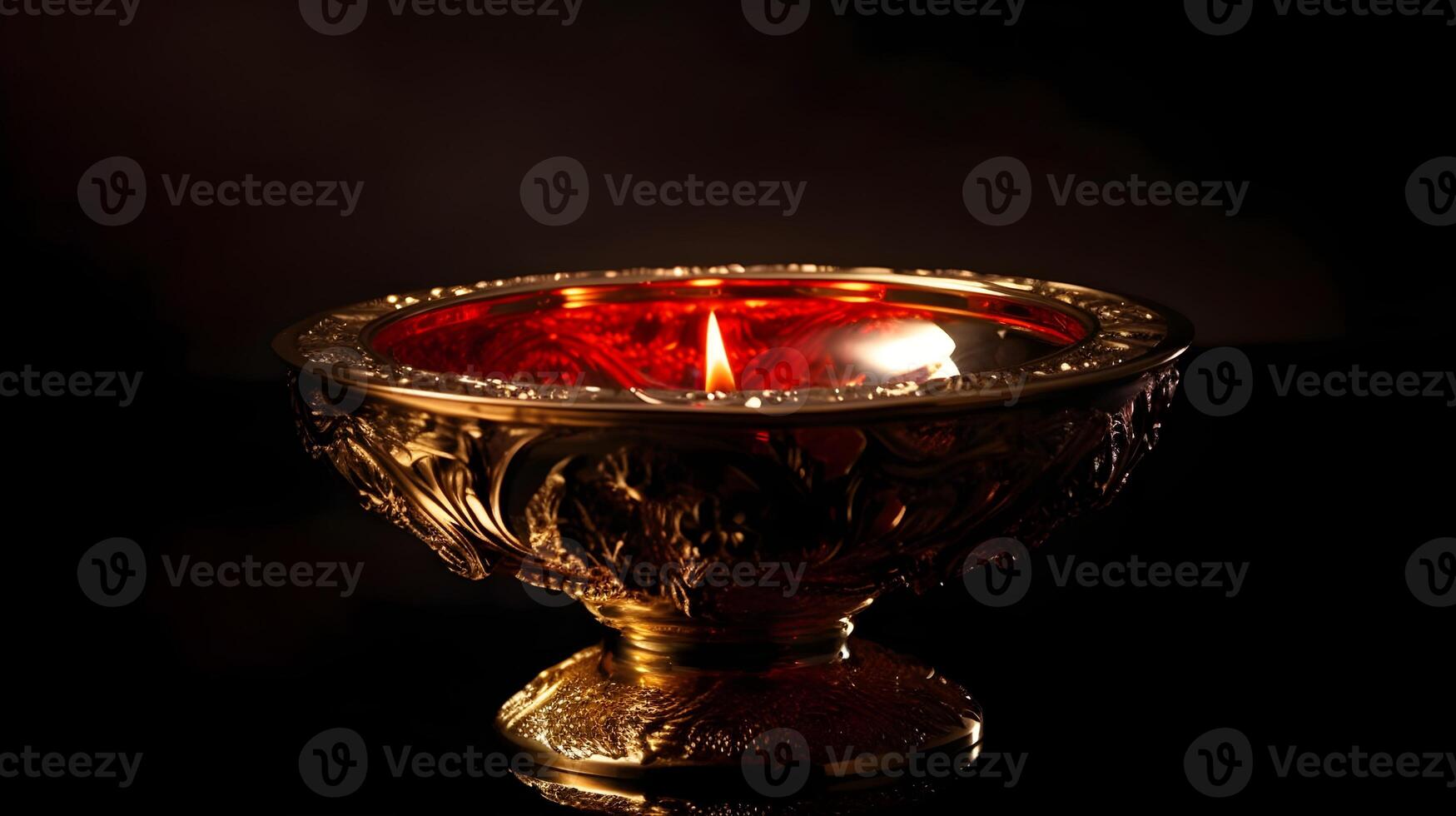 Burning decorative candle in a artistic brass cup, isolated on a black dark background studio shot. photo