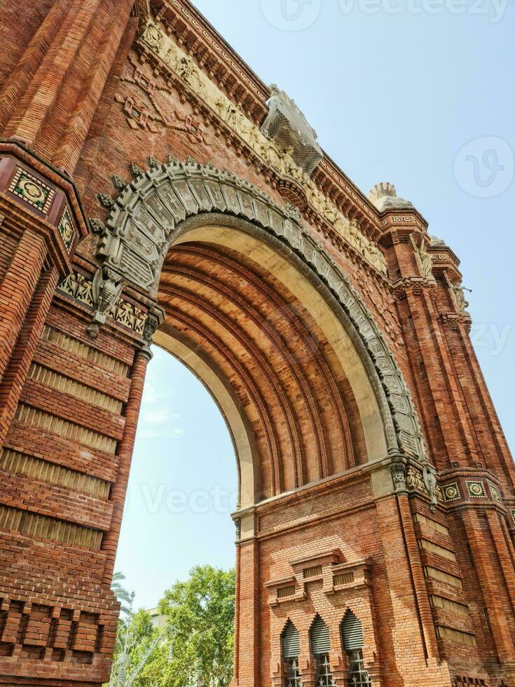 The Arc de Triomf in Barcelona on a sunny day with some tourists photo
